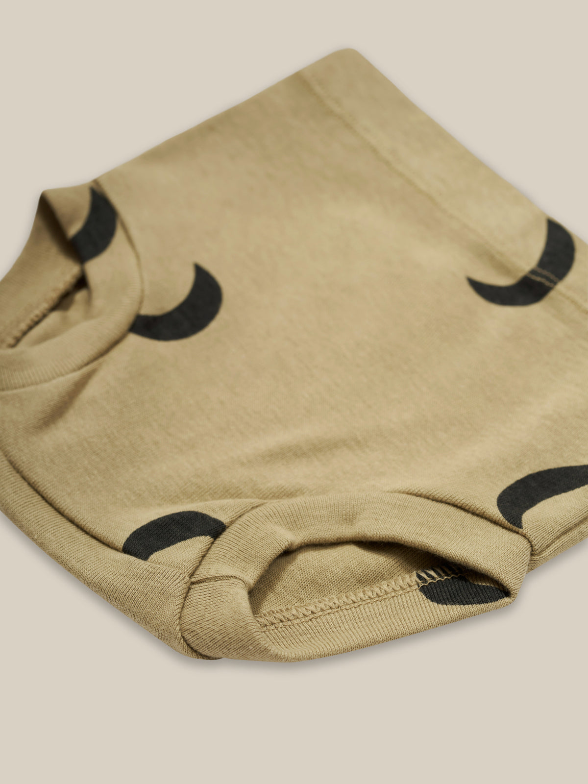 close up of baby & toddler dusky beige organic ribbed cotton shortie with black moon print
