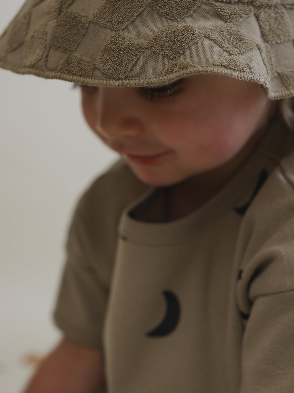 close up of toddler beige checkerboard soft organic terry cotton sun hat brim