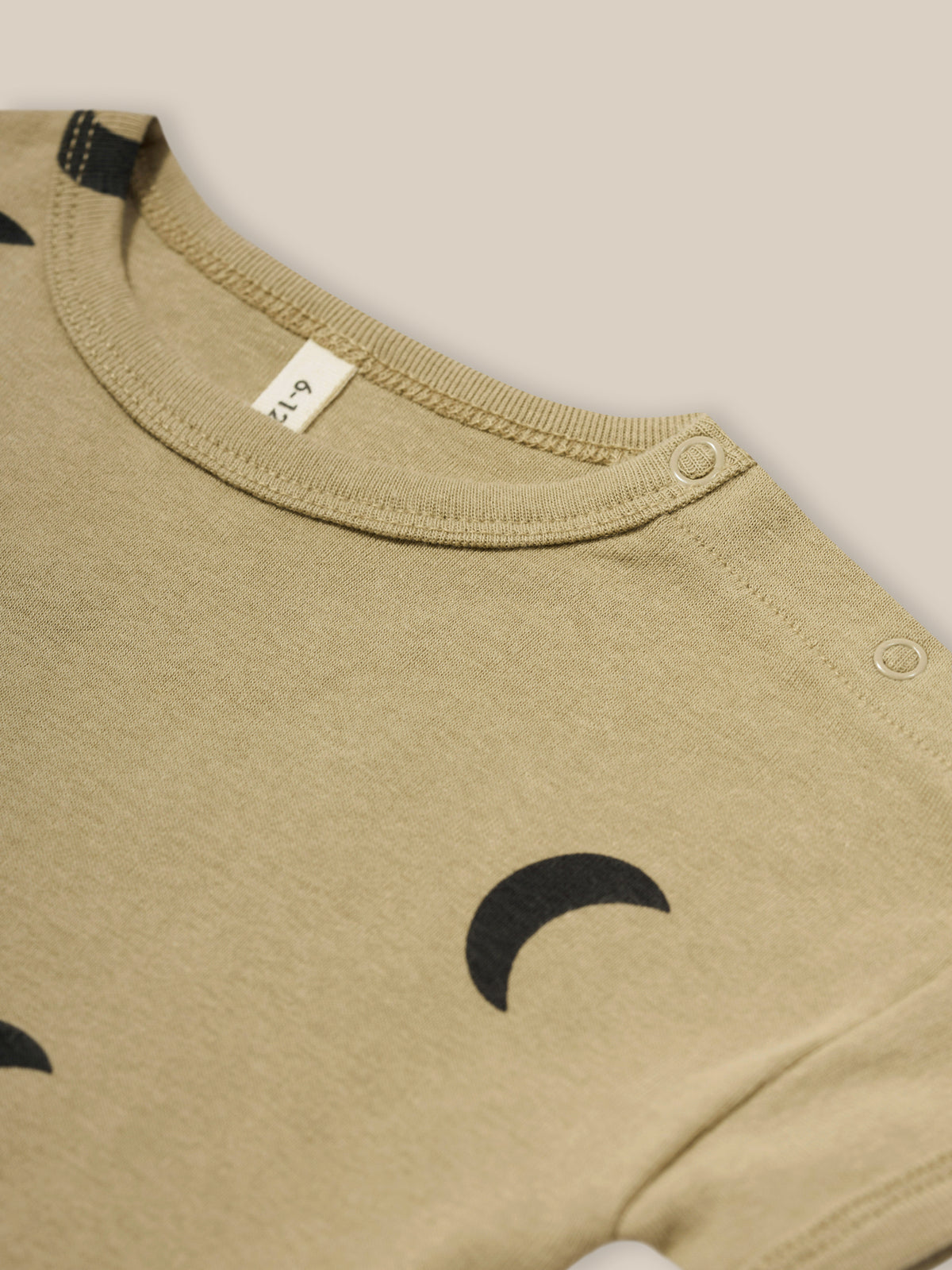 close up of baby dusky beige organic ribbed cotton boxy drop shoulder t-shirt with shoulder poppers