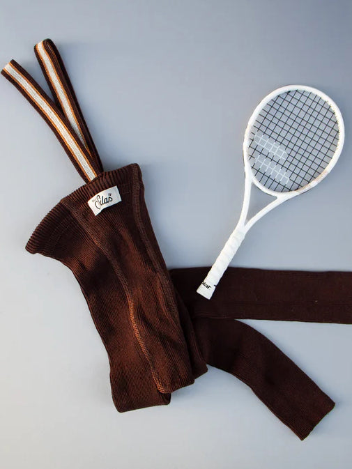 flat lay of toddler chocolate ribbed cotton footless tights with contrast striped braces and white tennis racket