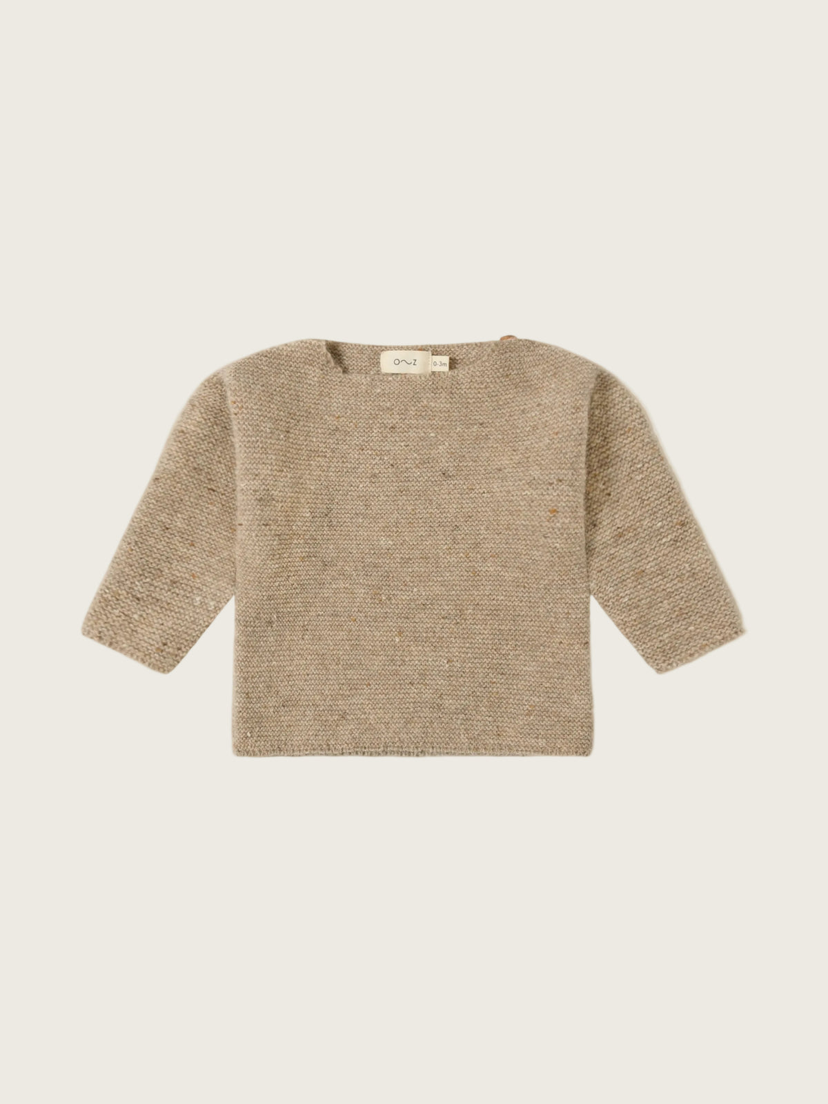 A textured knit long-sleeve sweater in a warm beige/tan color, laid flat against a solid off-white background.