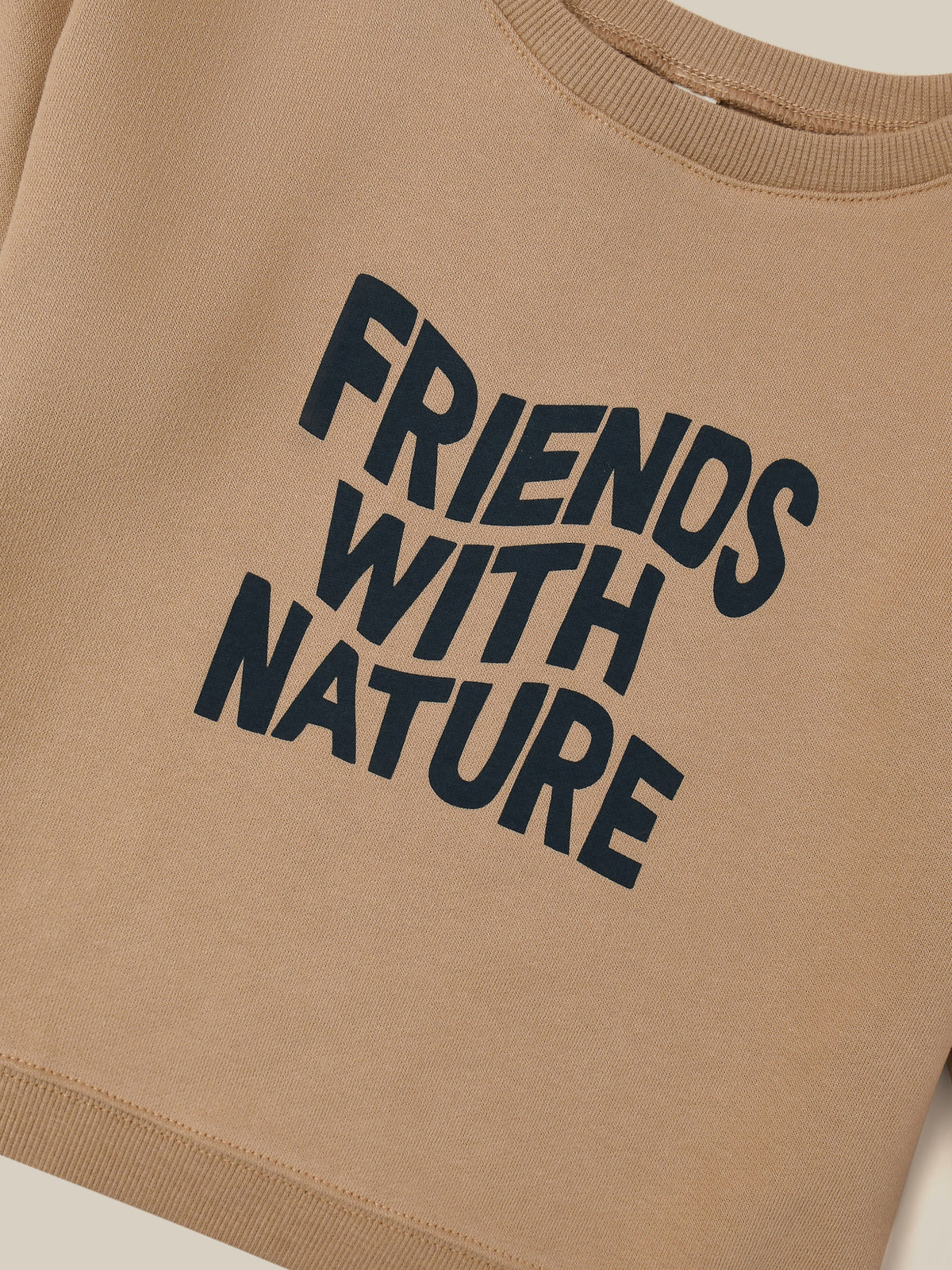 close up of brown sweater with FRIENDS WITH NATURE in wavy text across the front