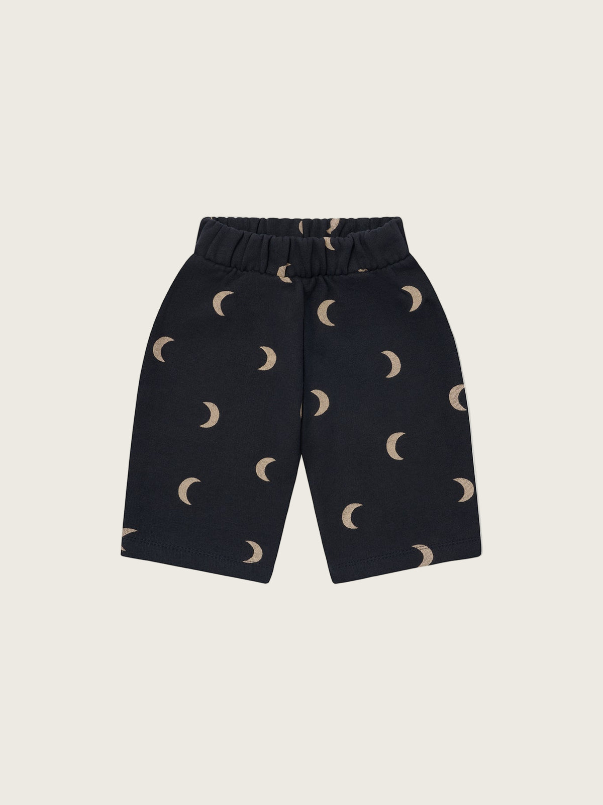 Black pants with moon pattern on a beige background