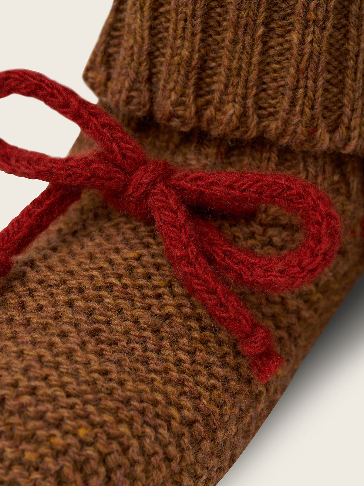close up of wool booties in chestnut brown with ribbed cuffs and red ribbons