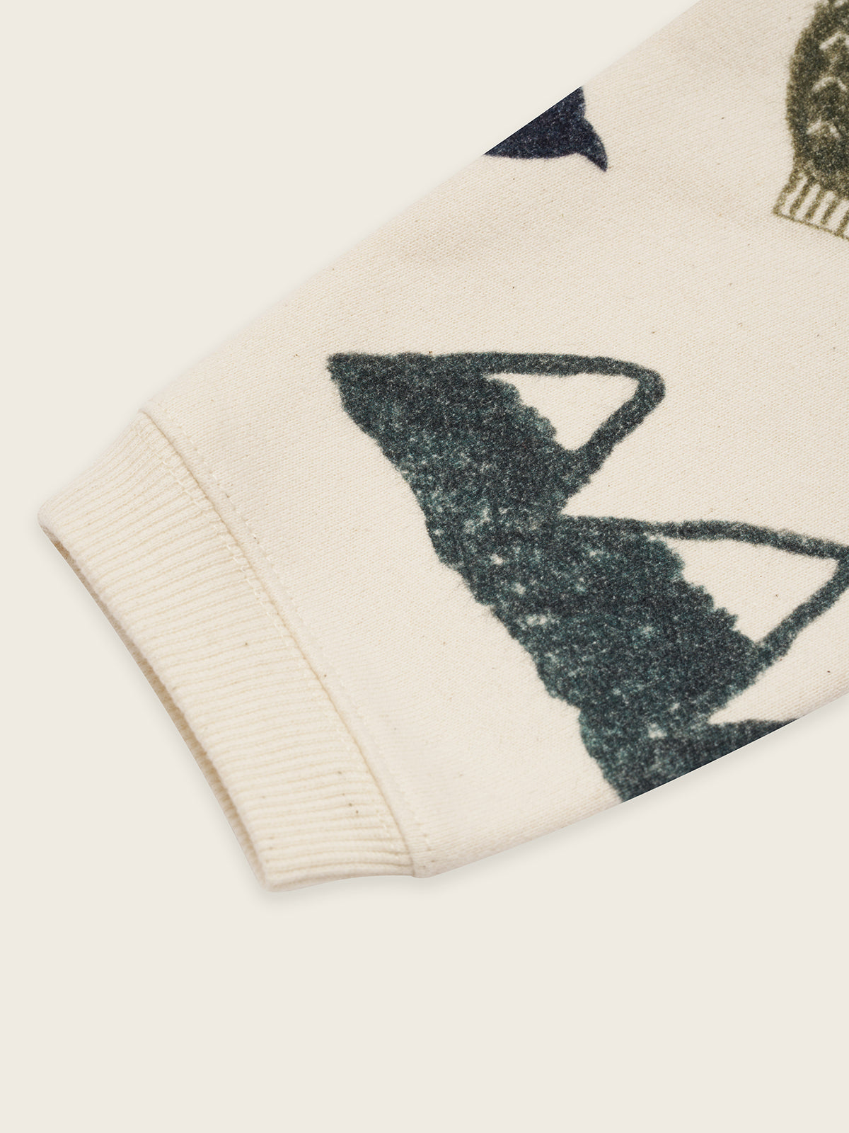 close up of cream undyed cotton sweatshirt with cosy nature-themed graphics of mountains, trees, and birds