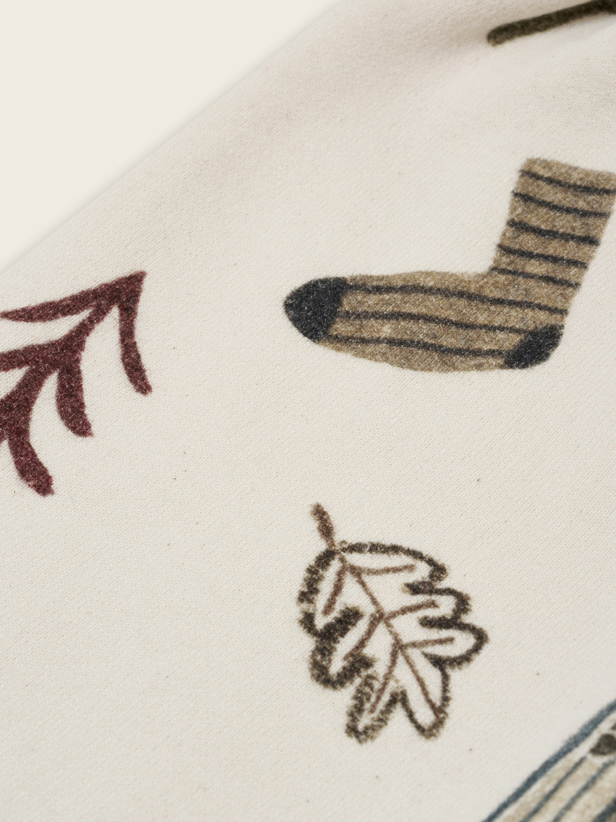 close up of cream undyed cotton wide leg pants with cosy nature-themed graphics