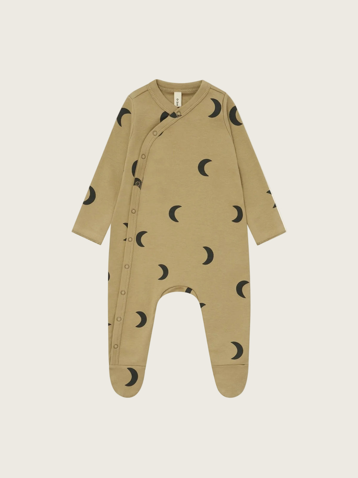 A baby long-sleeve footed sleeper in a warm tan color, featuring a black crescent moon pattern all over and snap buttons down the front, shown on a plain white background.