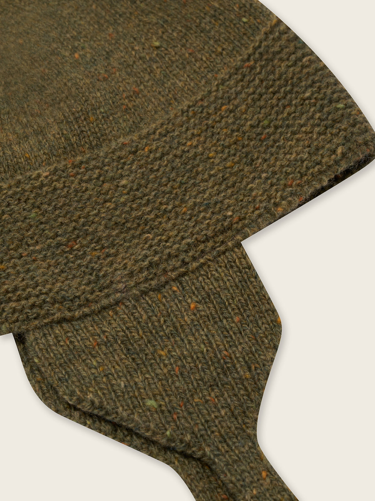 close up of wool hat in forest green with brown tassel and chin tie