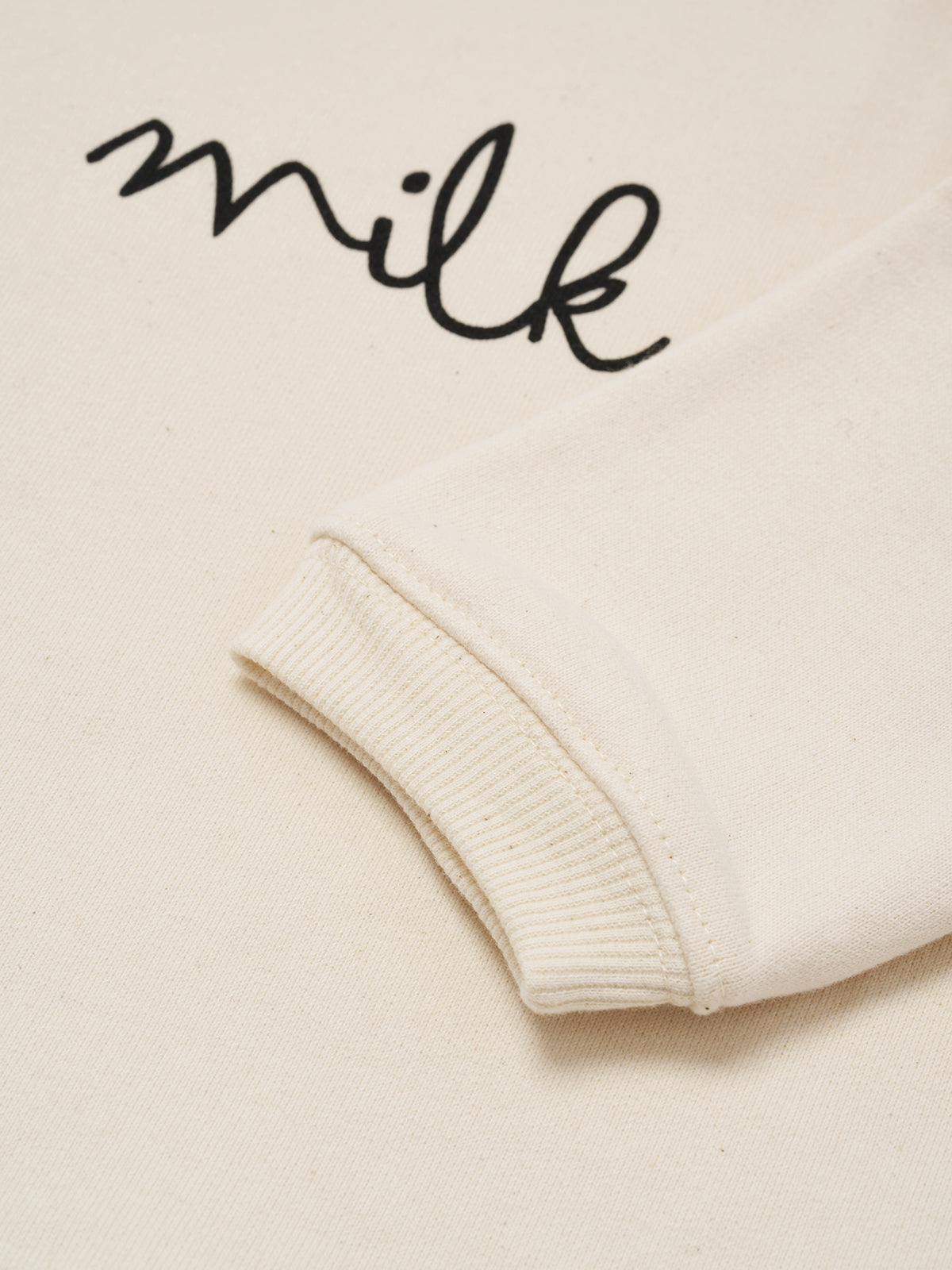 close up of cream undyed cotton boxy drop shoulder sweatshirt with milk text