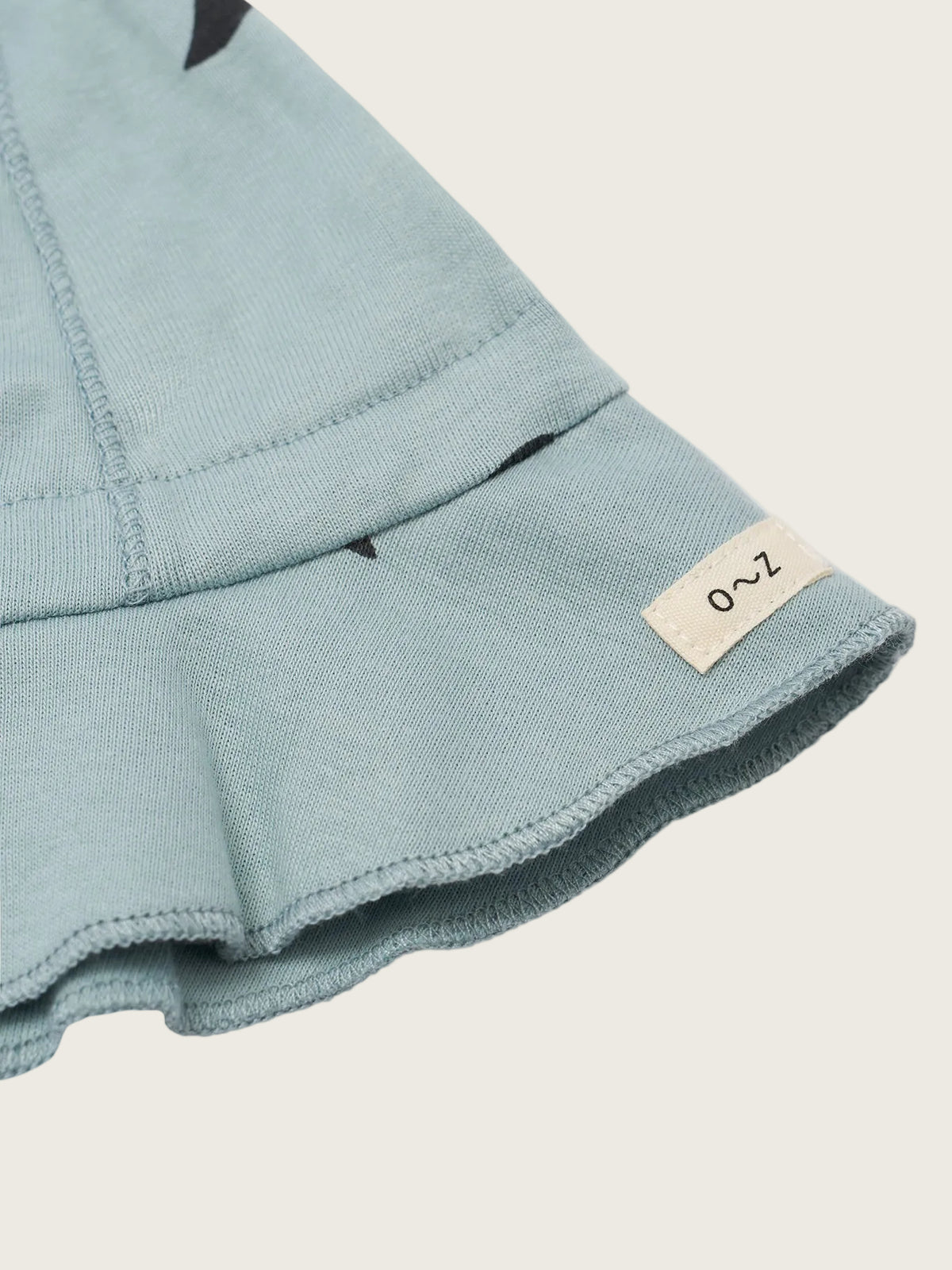 Close-up of a light blue fabric with a brand label on a white background