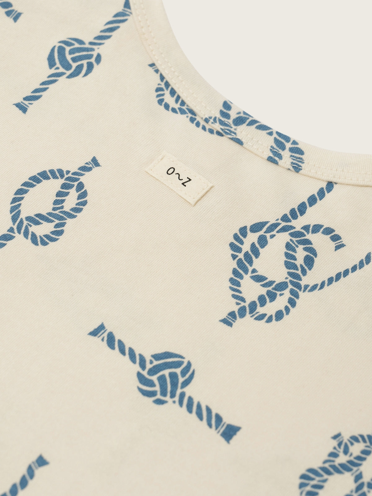 Beige fabric with blue rope pattern and a label on a white background