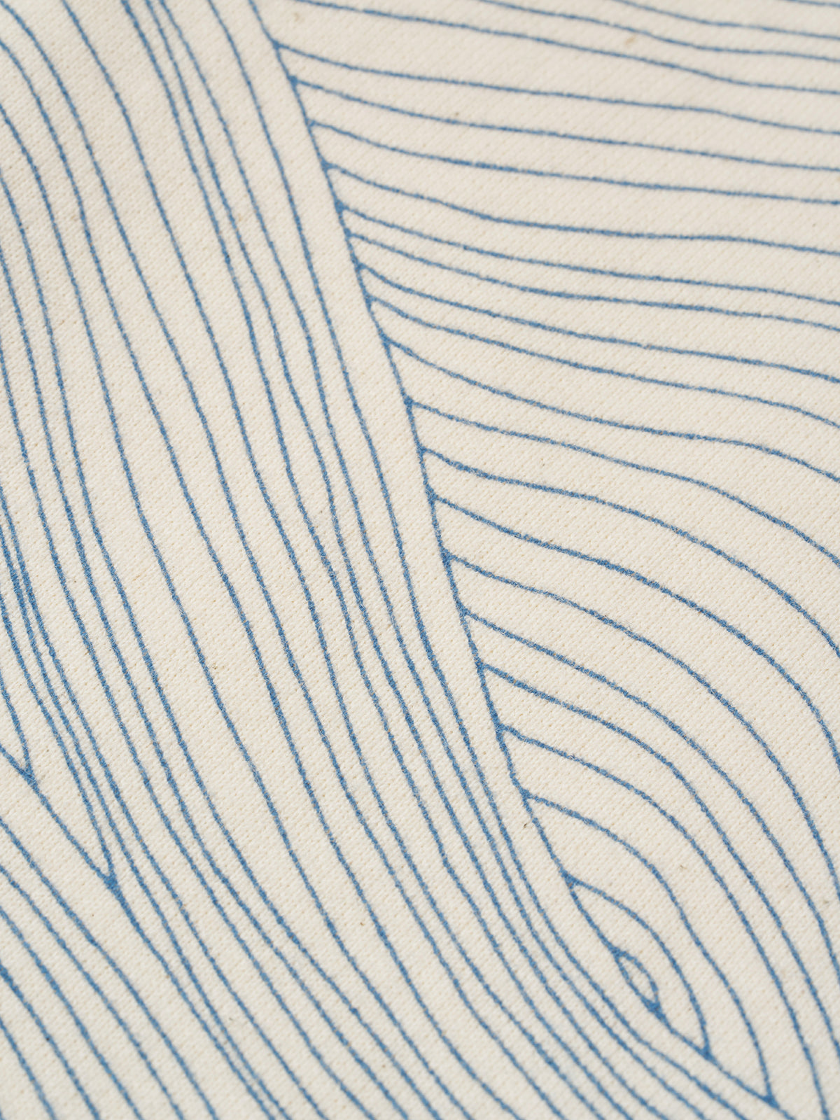 close up of cream undyed cotton wide leg drawstring pants with blue line-drawn ocean waves