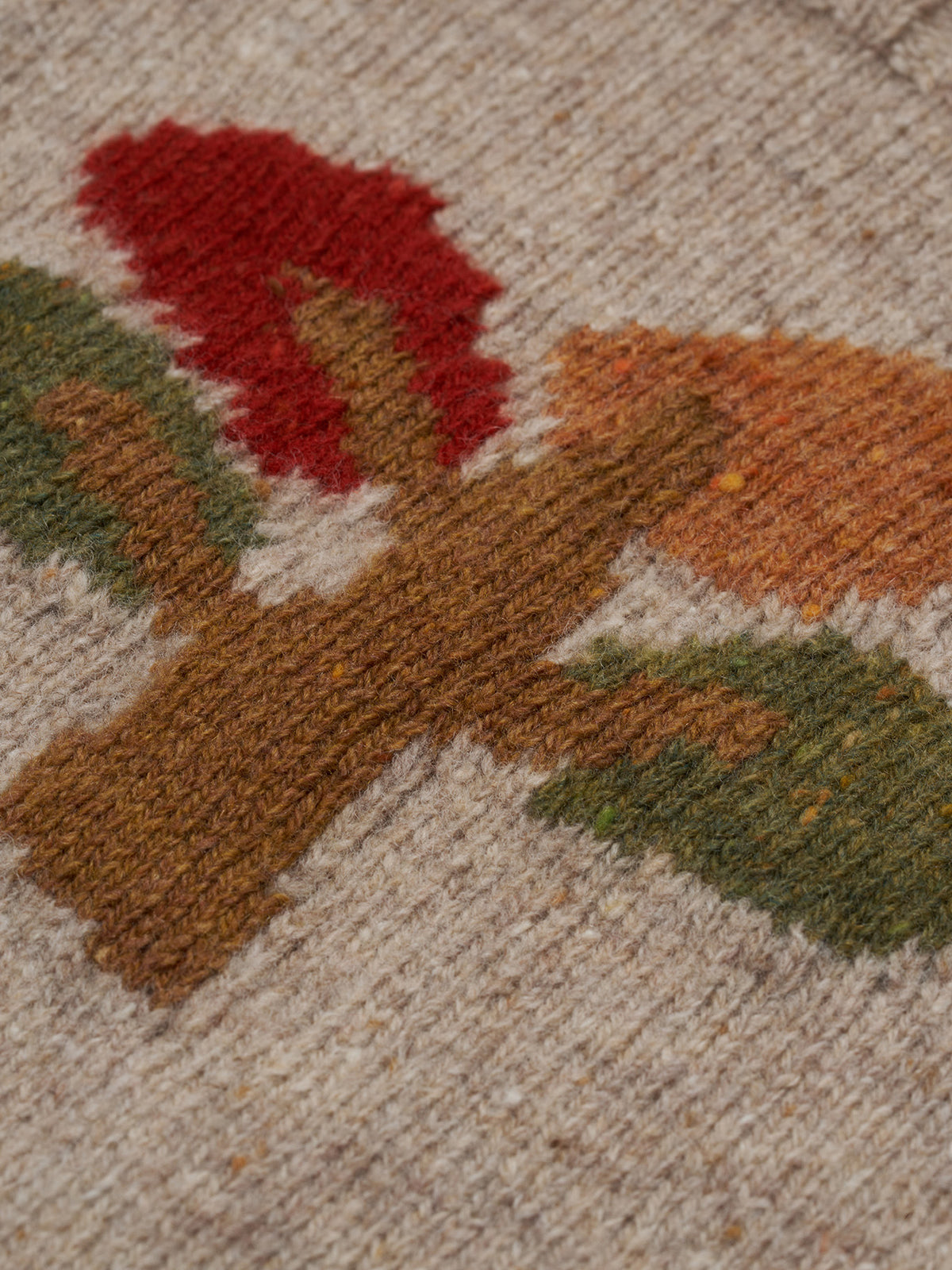 close up of beige wool jumper with square neck, ribbed trim & tree motif in red, orange, green