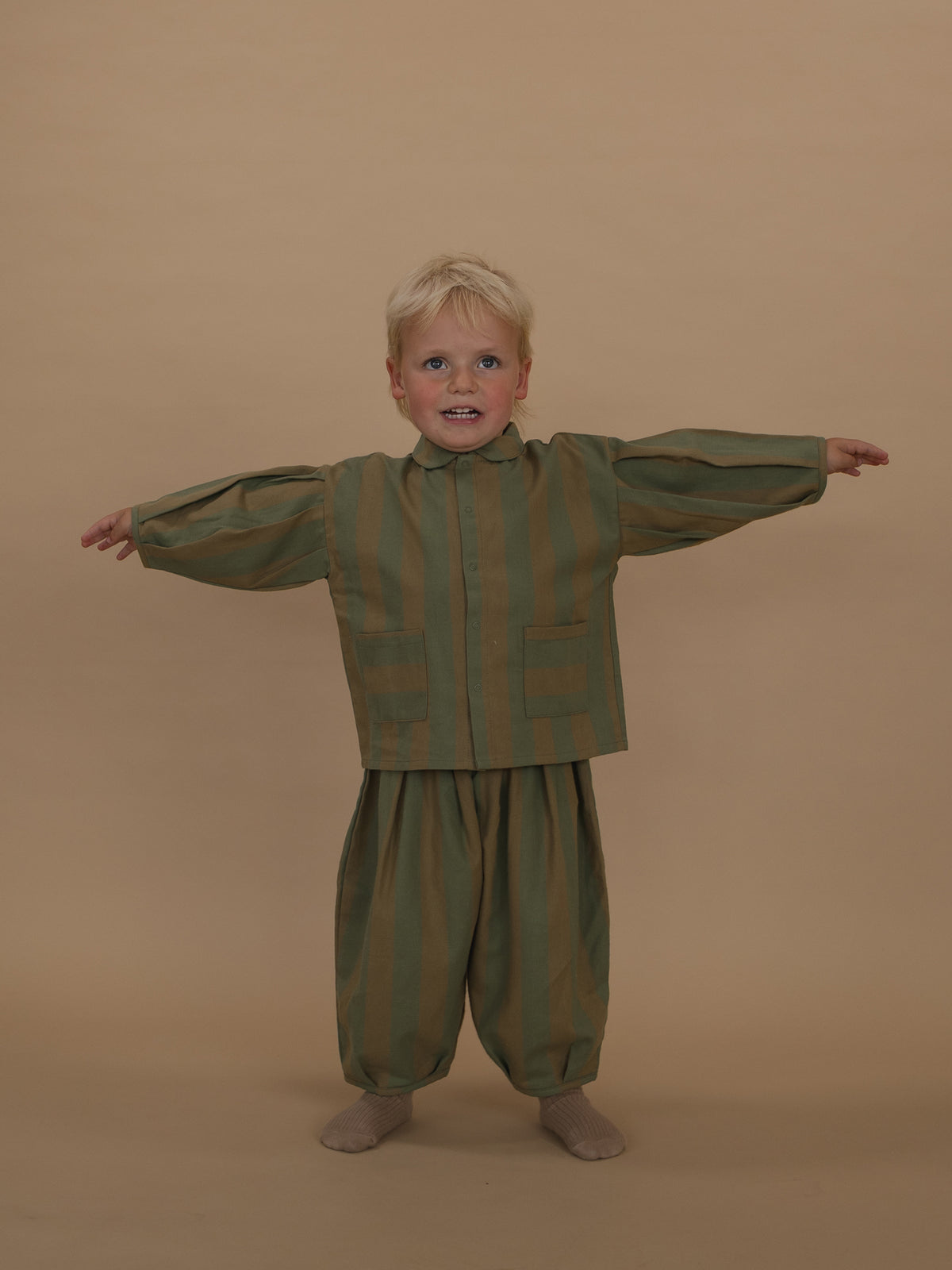 toddler in stripes lodge shirt with balloon sleeves with matching balloon pants standing with arms out