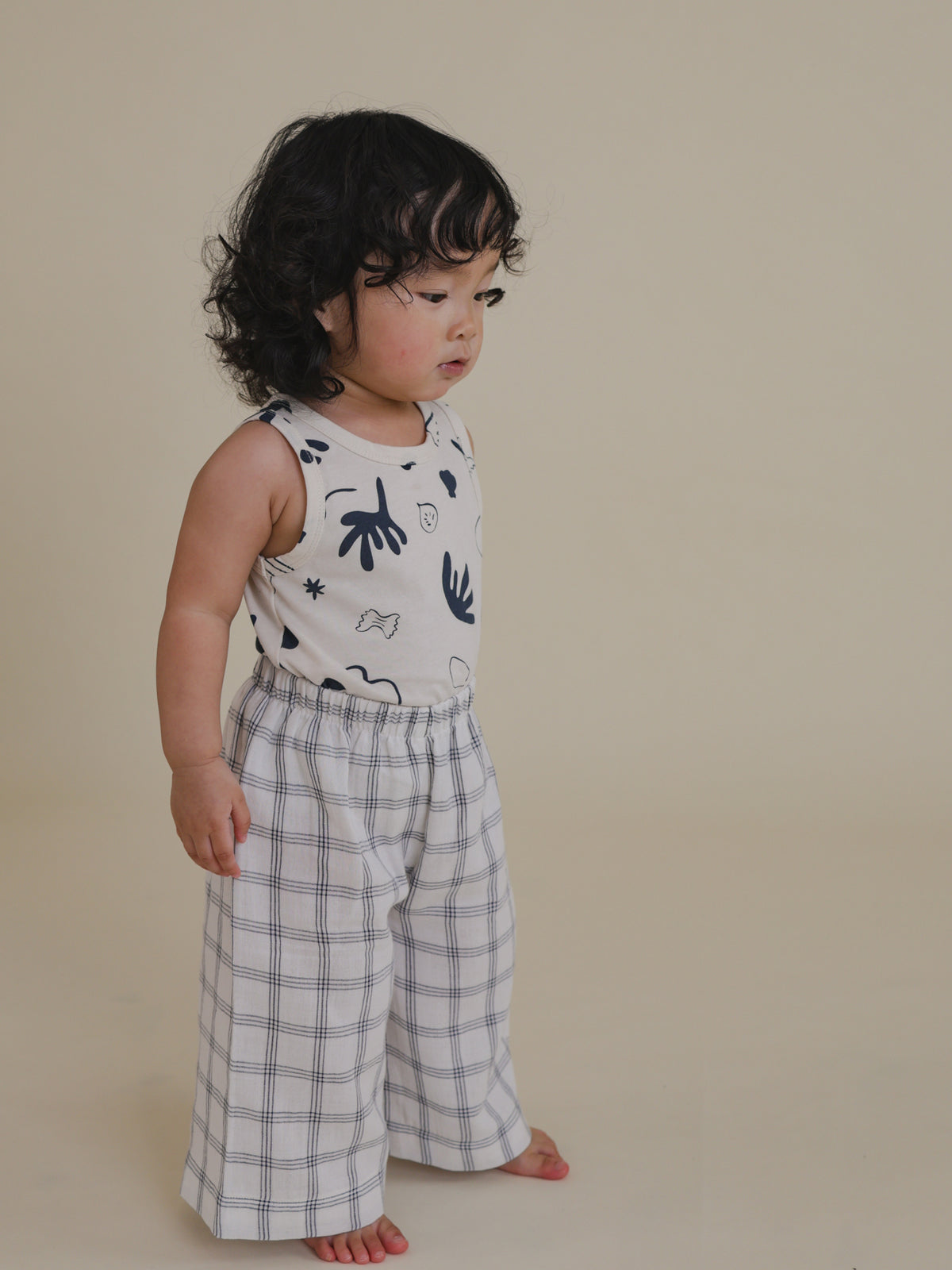 toddler in white muslin wide leg trousers with navy window check print & elasticated waist