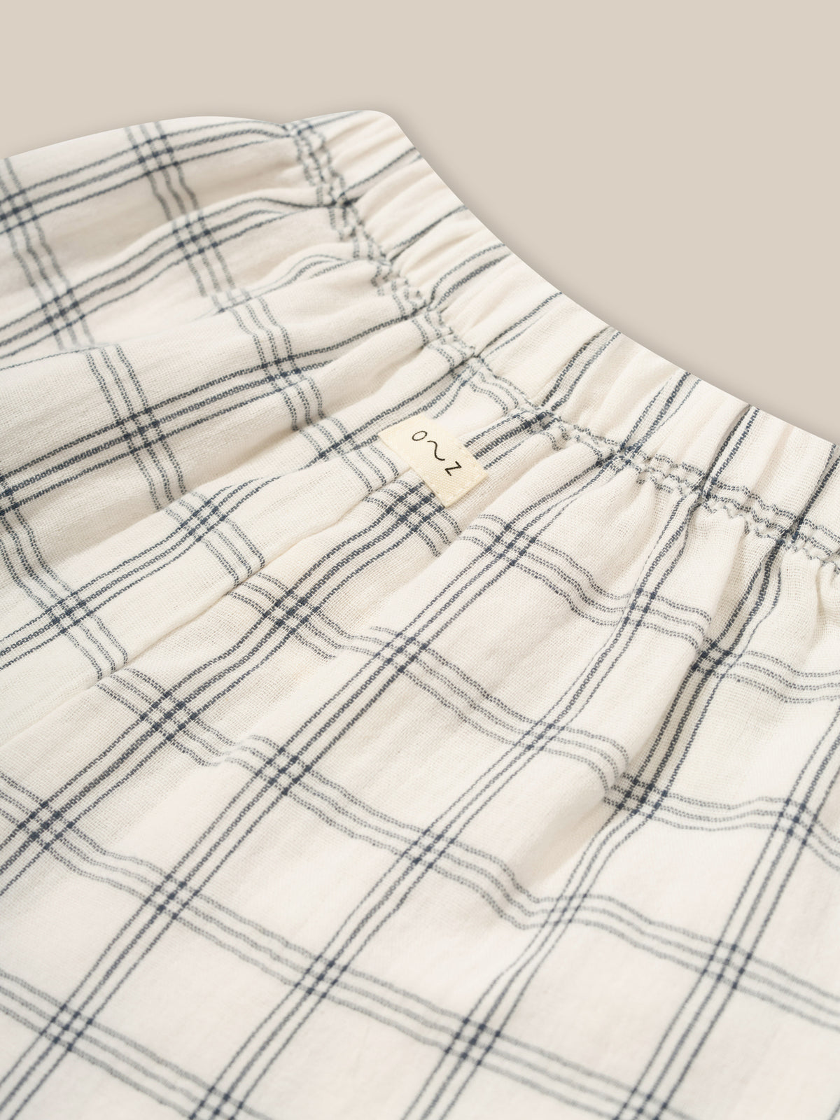 close up of toddler wide leg muslin trousers in white with window check print & elastic waistband