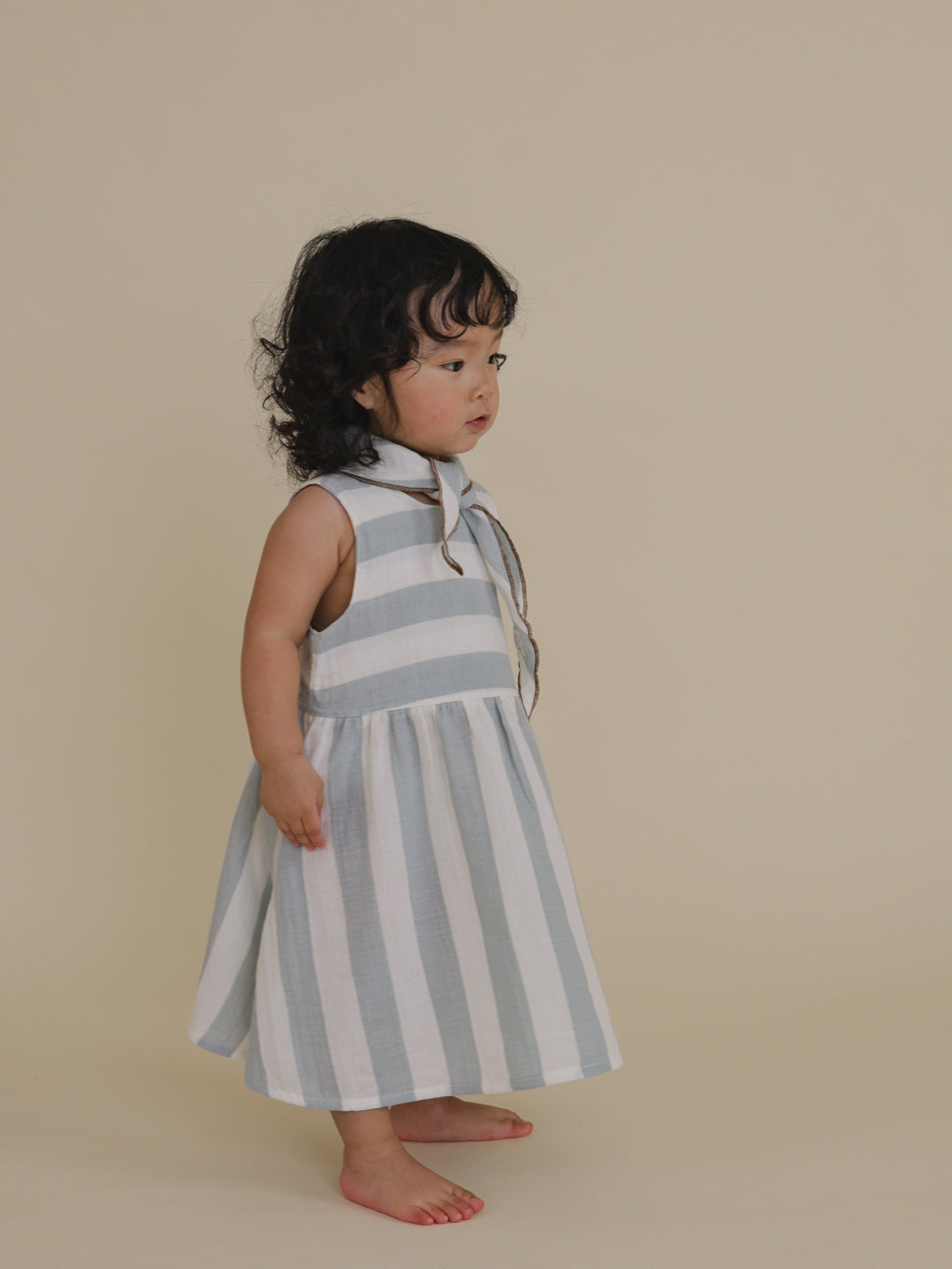 toddler in organic cotton muslin sleeveless dress with blue & white stripes