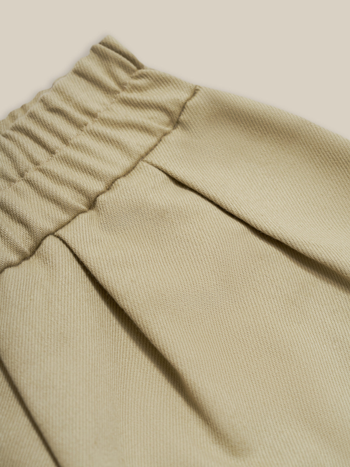 close up of toddler organic twill sea salt grey barrel trousers with pleats, elastic waistband & curved hem