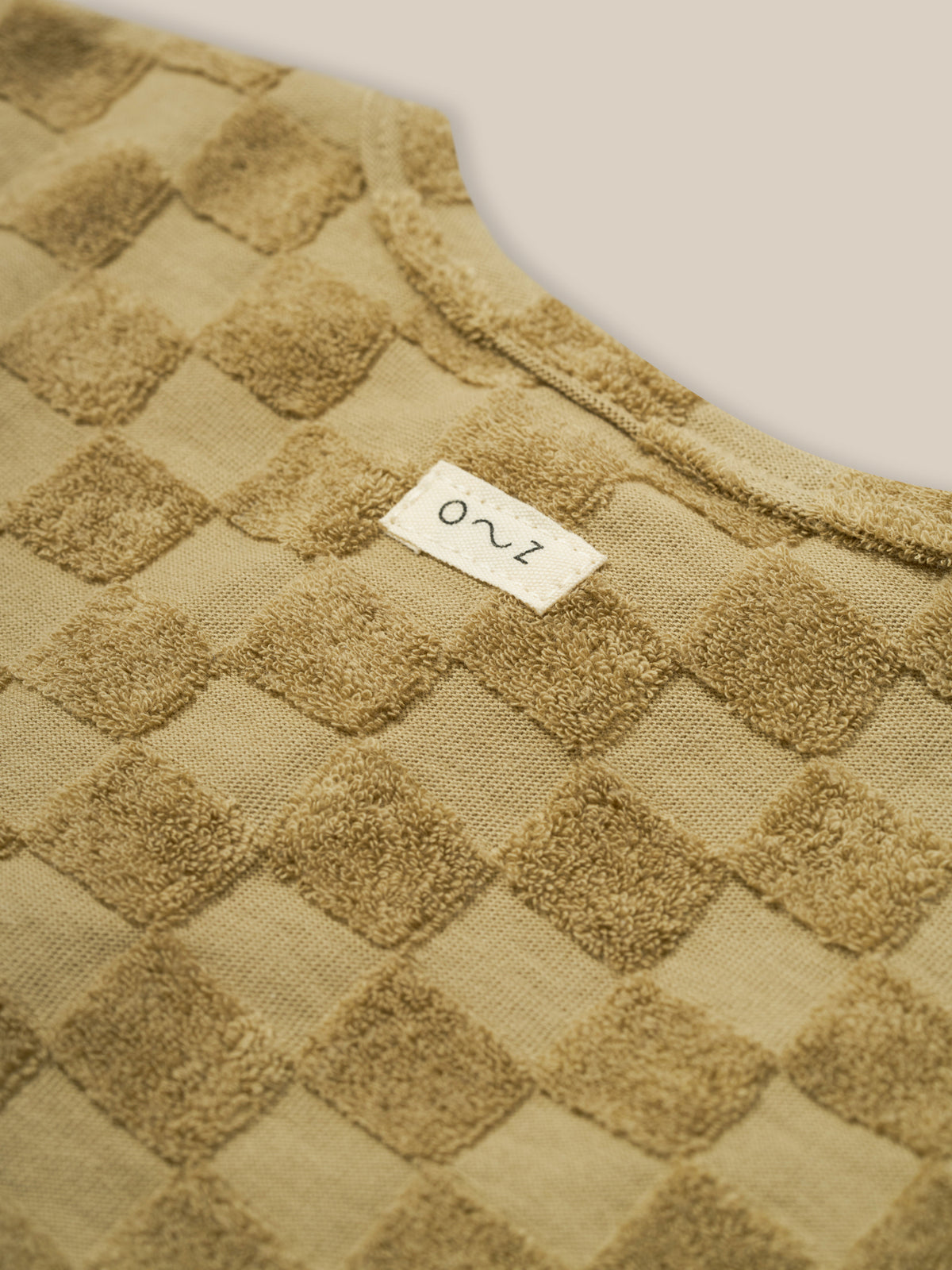 close up of baby & toddler dusky beige checkerboard boxy t-shirt in organic terry cotton