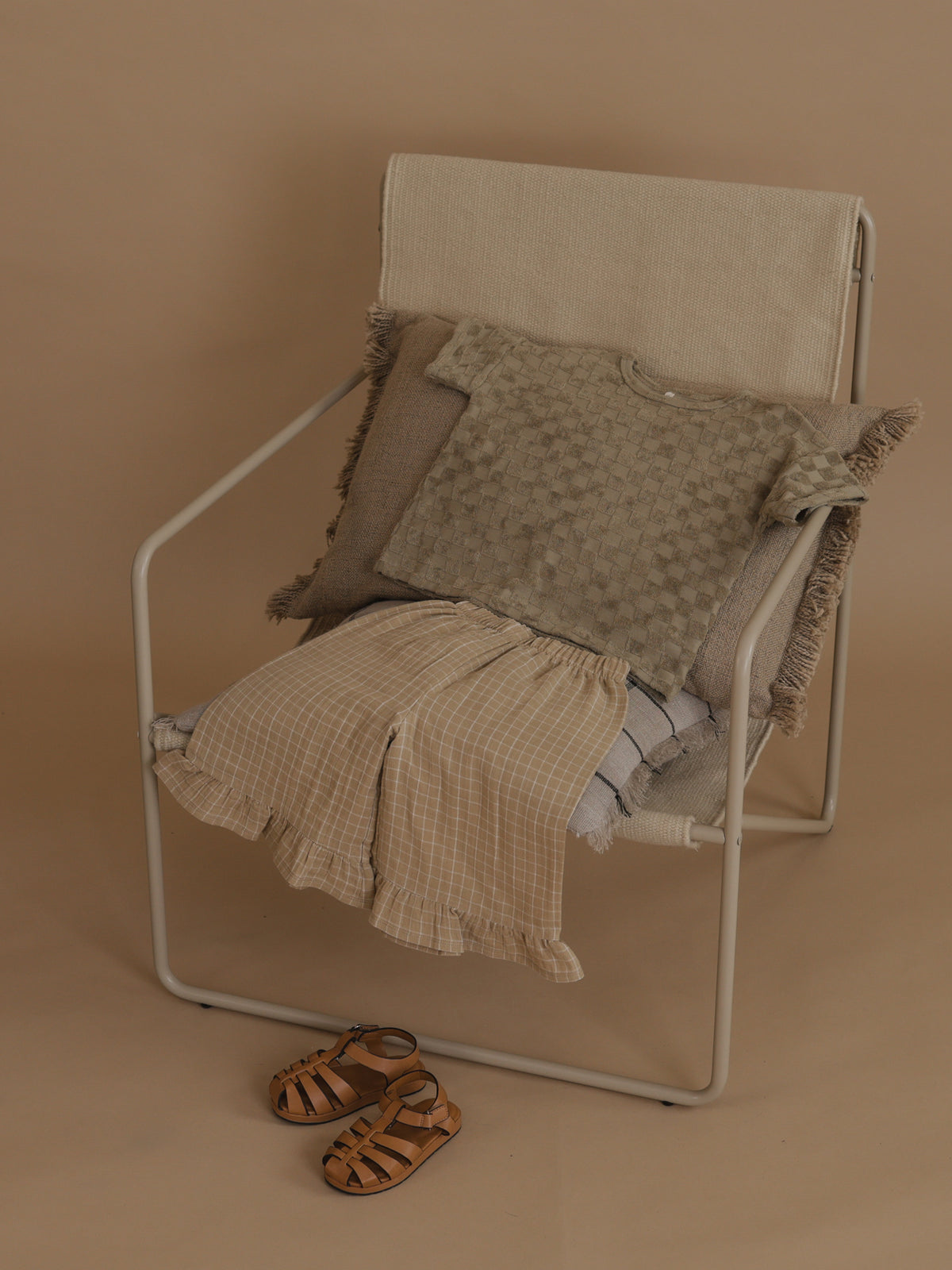 toddler terry cotton beige boxy checkerboard t-shirt draped over cushion on chair