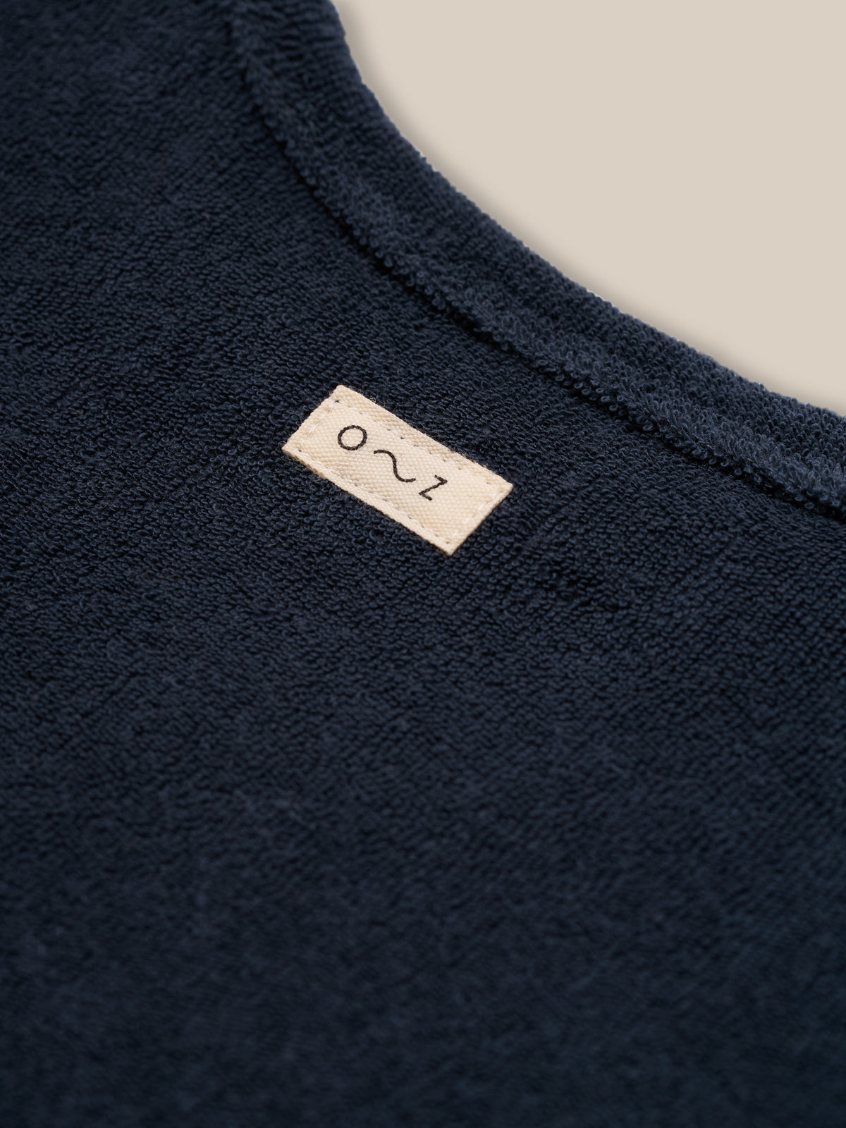 close up of baby & toddler organic terry cotton navy boxy t-shirt with o~z label on the back