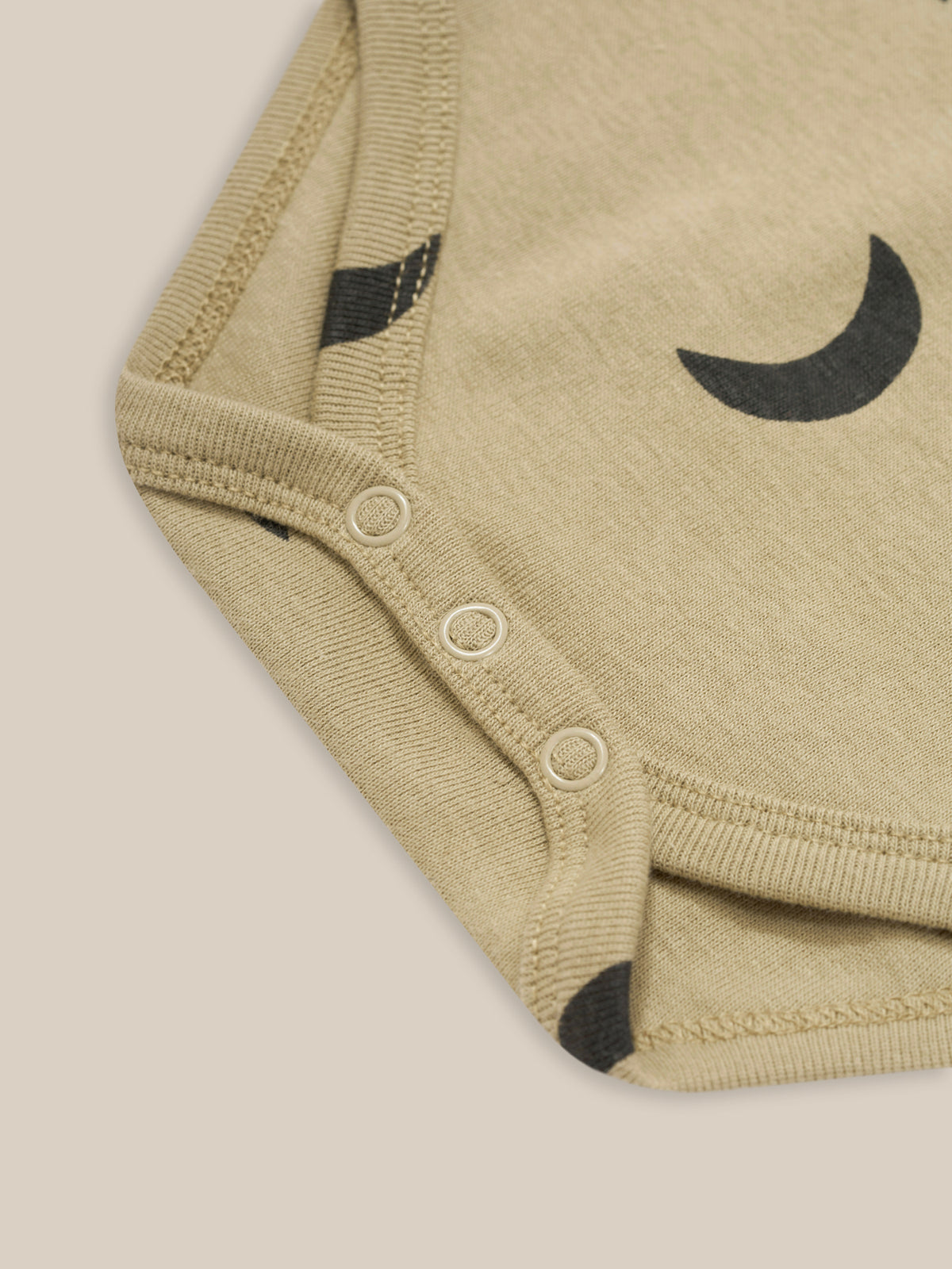 close up of baby dusky beige organic ribbed cotton short sleeved bodysuit with shoulder & crotch poppers