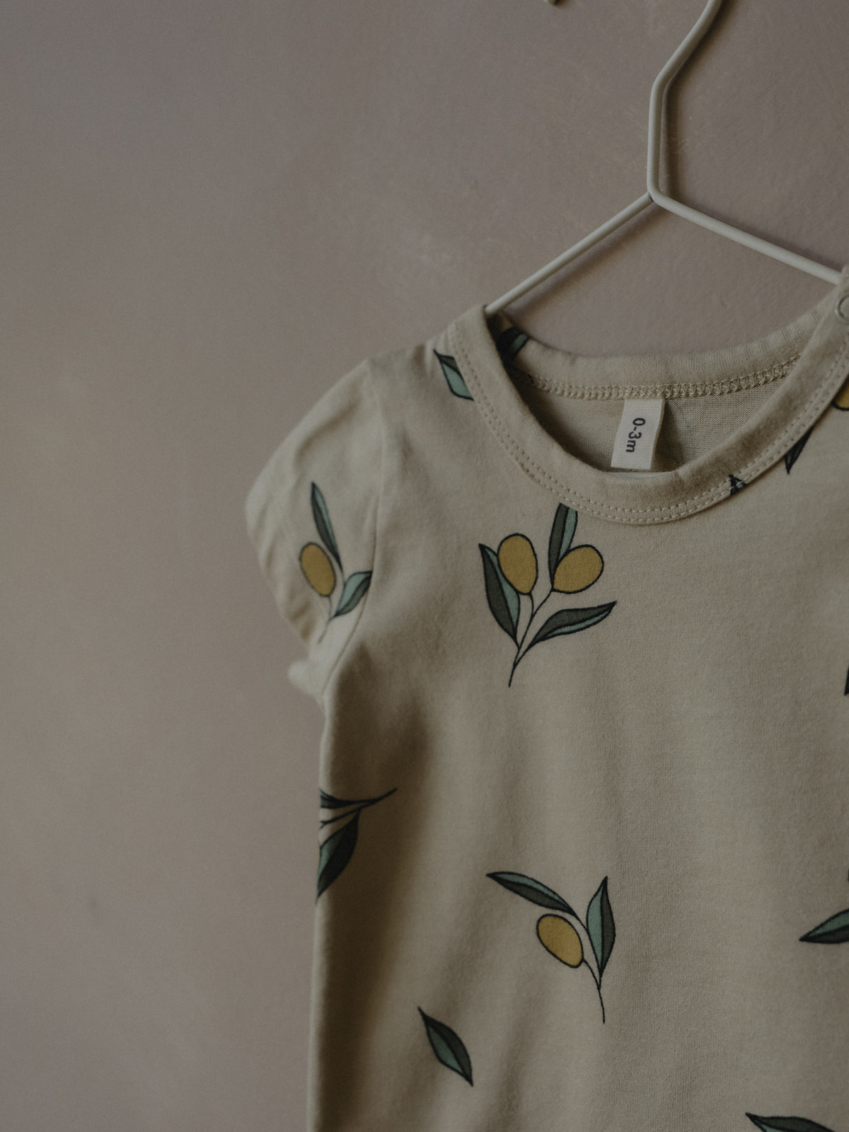 short sleeve baby bodysuit in cream with olives in details