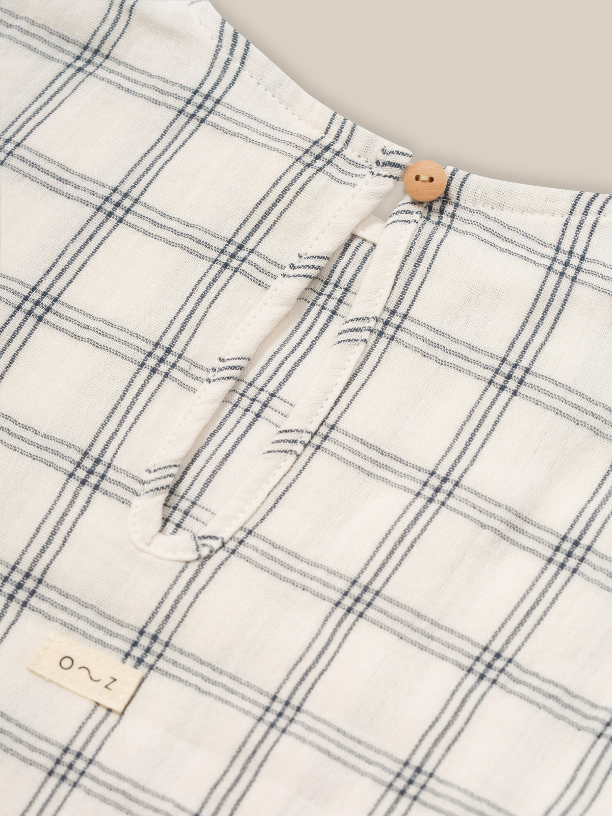 close up of baby & toddler muslin boxy navy window check t-shirt keyhole with button & loop