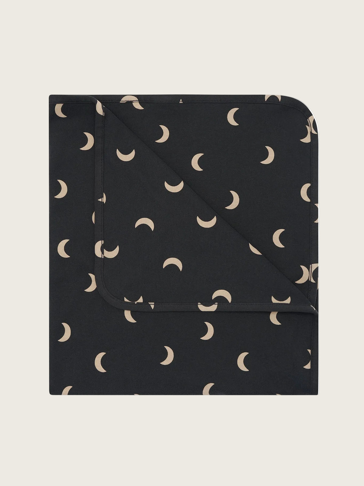 Black blanket with beige crescent moon pattern on a white background
