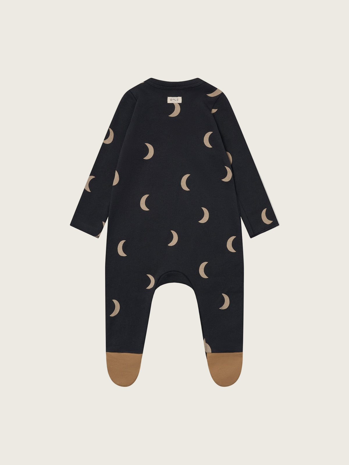 Black baby onesie with moon pattern on a beige background