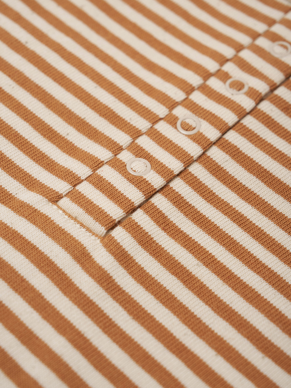 Close-up of brown and white striped fabric with button details
