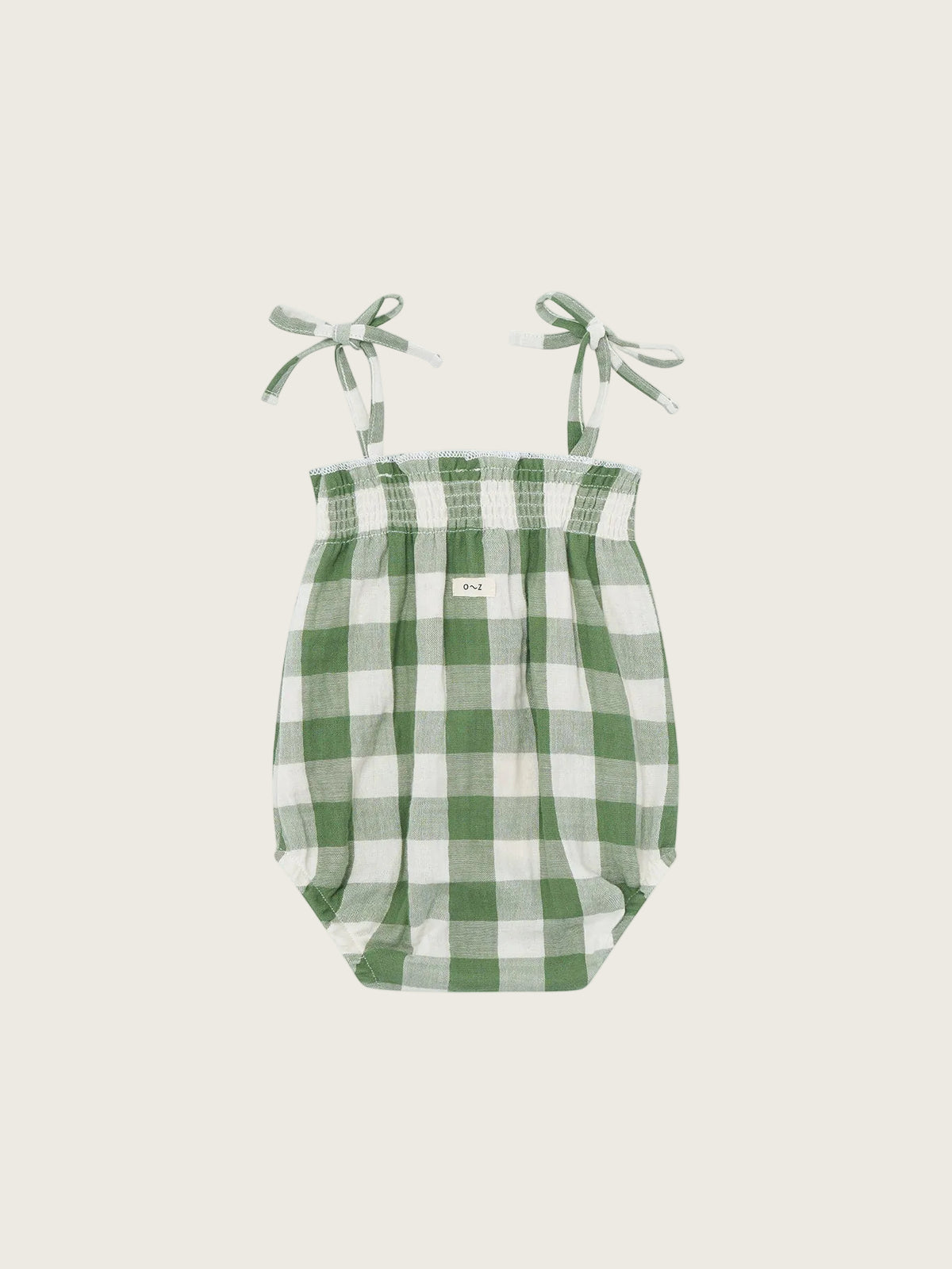 Green and white checkered baby bodysuit with straps on a white background