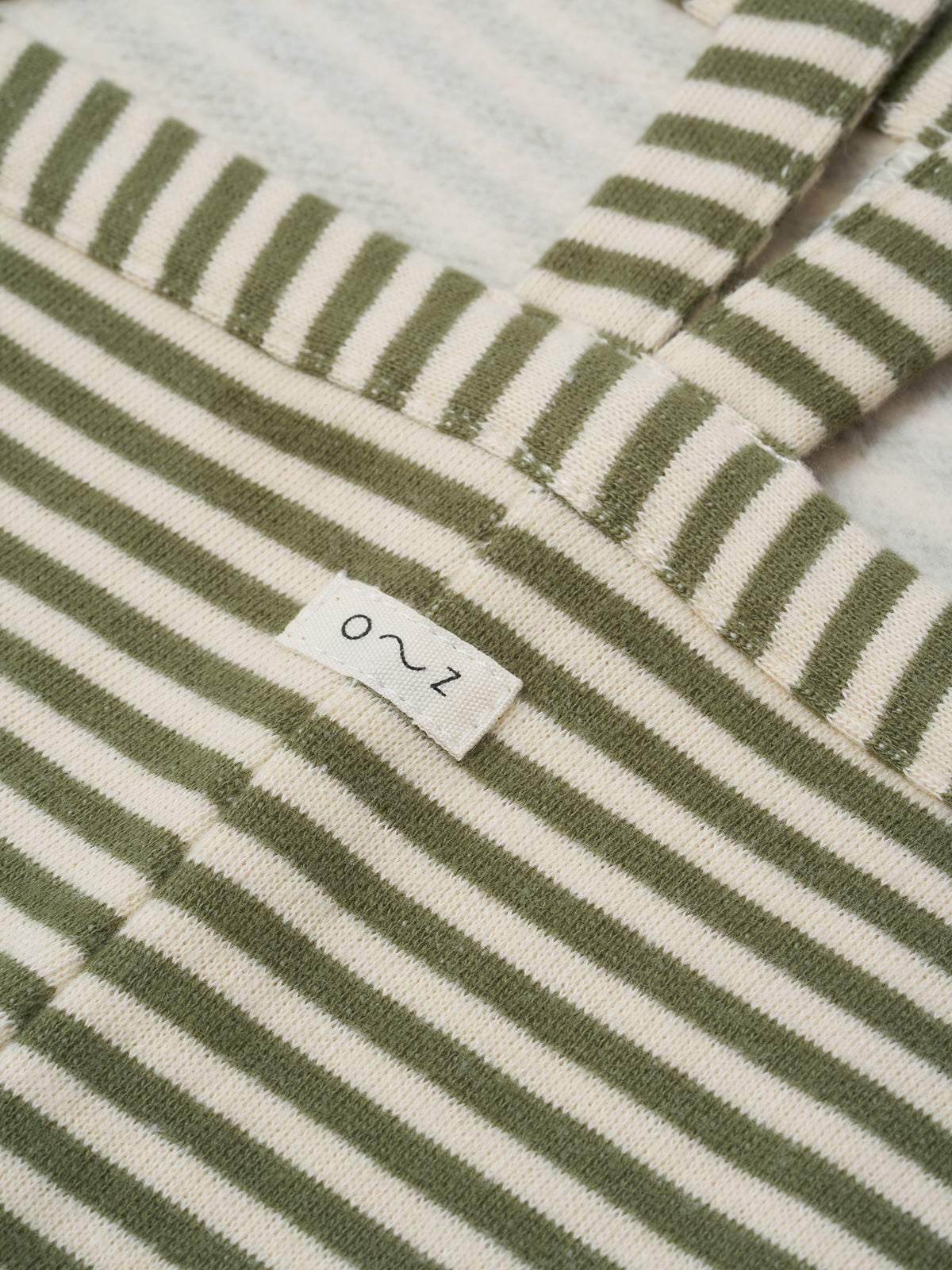 close up of toddler oversized boxy terry cotton dungarees with green and white stripes