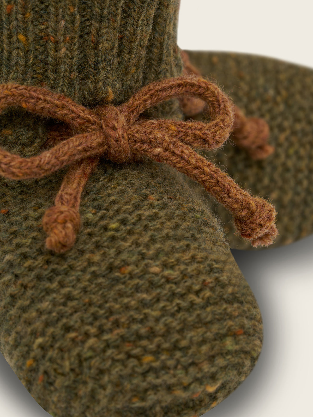 close up of wool booties in forest green with ribbed cuffs and brown ribbons