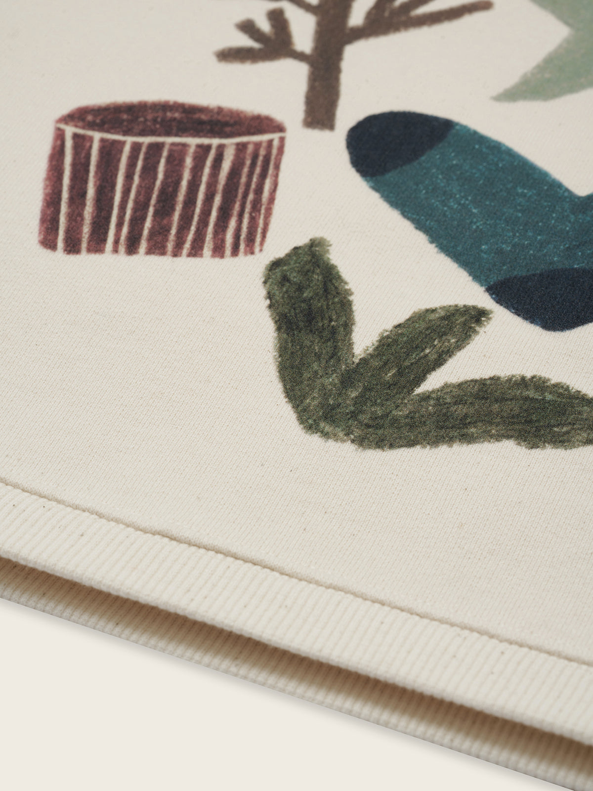 close up of cream undyed cotton sweatshirt with nature-themed graphic with socks and tree