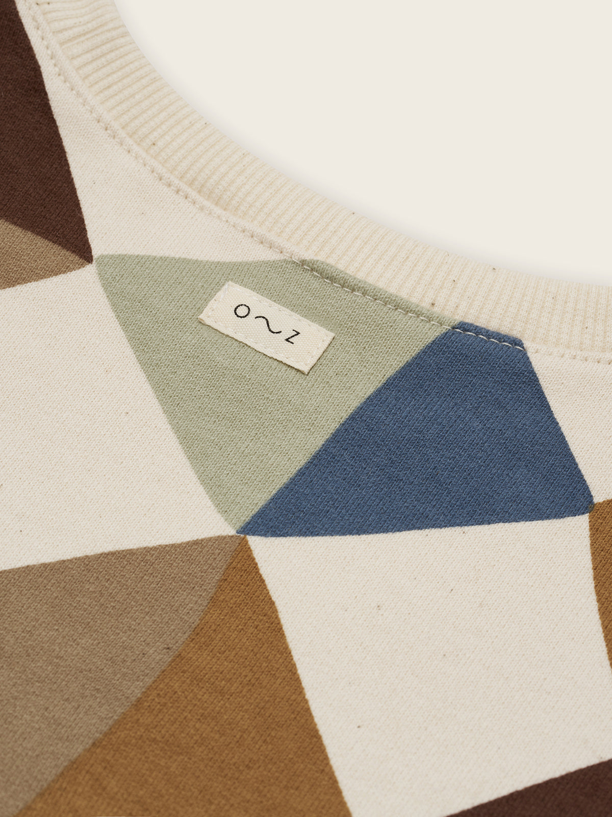 close up of cream undyed cotton sweatshirt with multicolour geometric patchwork diamond print