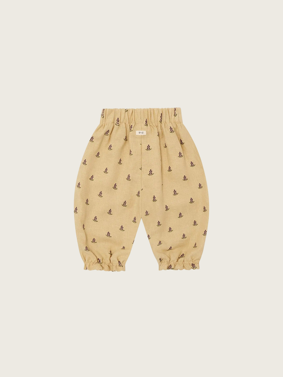 Beige baby pants with small patterns on a white background